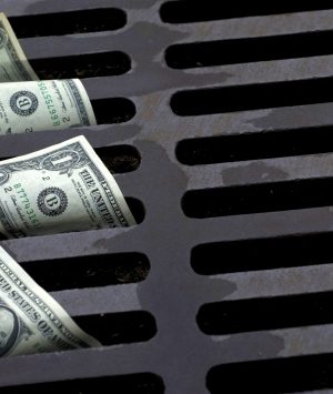 US Dollar bills down the street drain